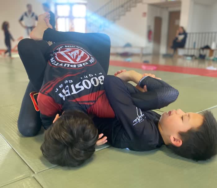 Two young grapplers working a submission on the mats at the Wewelsburg camp