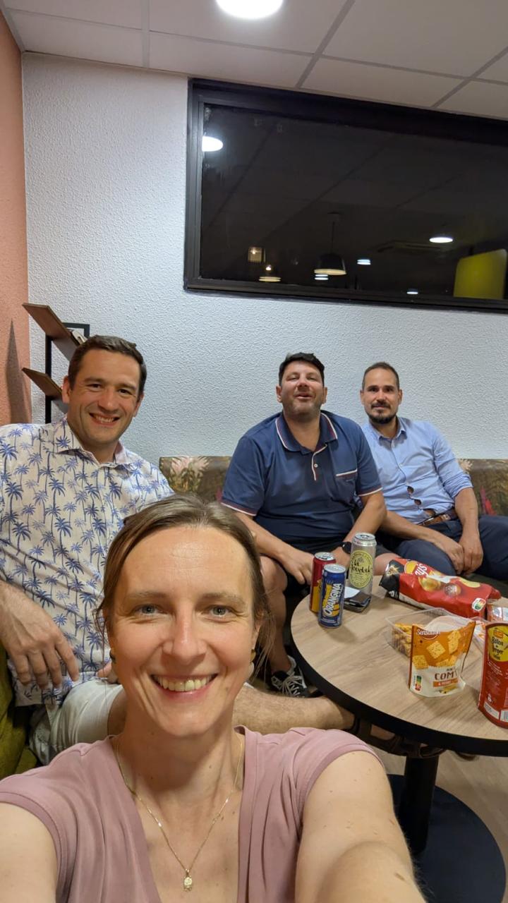 Four Dropsolid team members meeting in a hotel lounge in Paris late at night, with drinks and snacks on the table