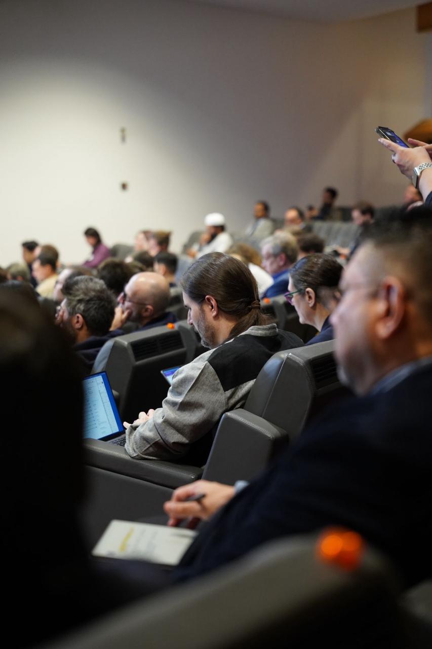 Second audience shot - engaged attendees with laptops and notebooks