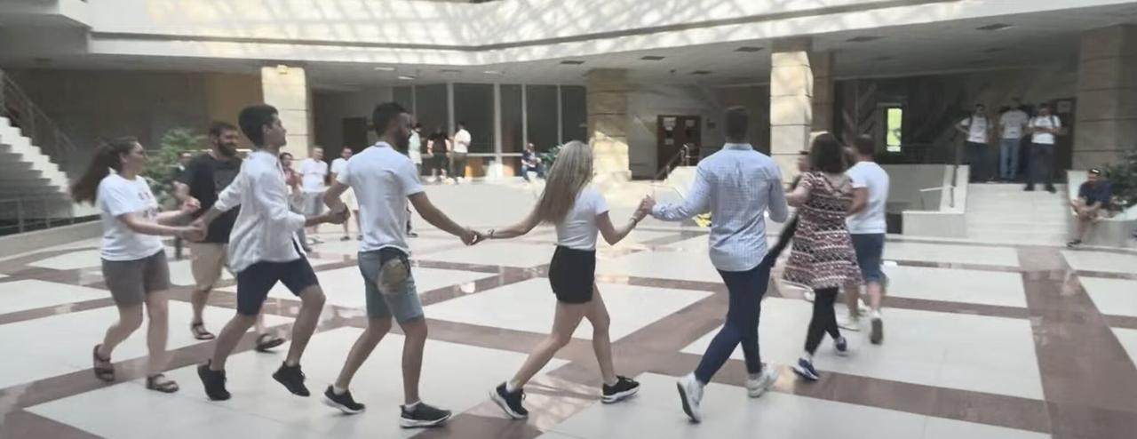 Participants dancing the horo, a traditional Bulgarian circle dance, in the university atrium