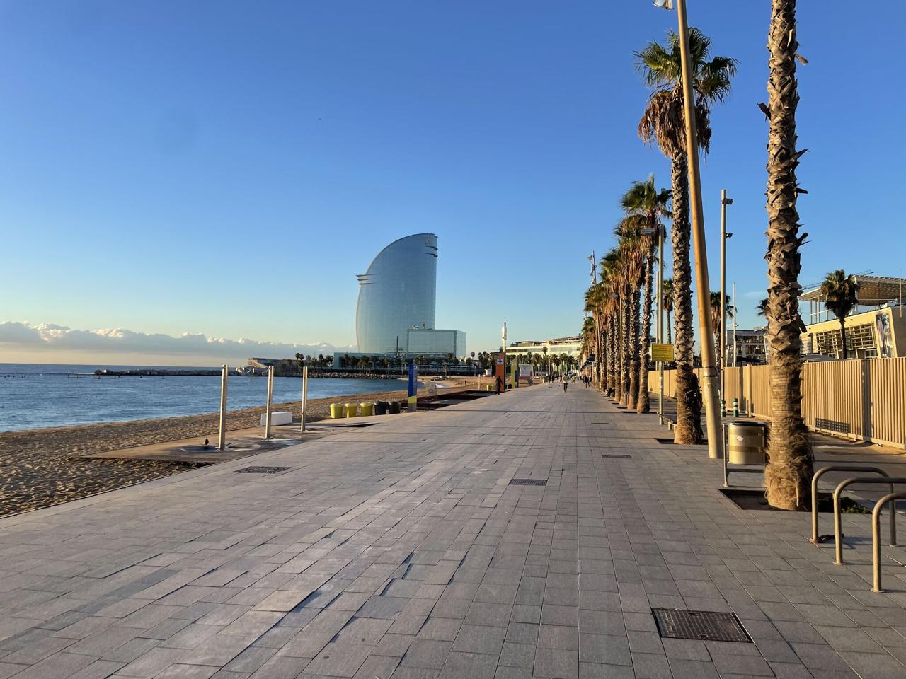 Early morning Barcelona beachfront promenade with palm trees and the W Hotel in the distance