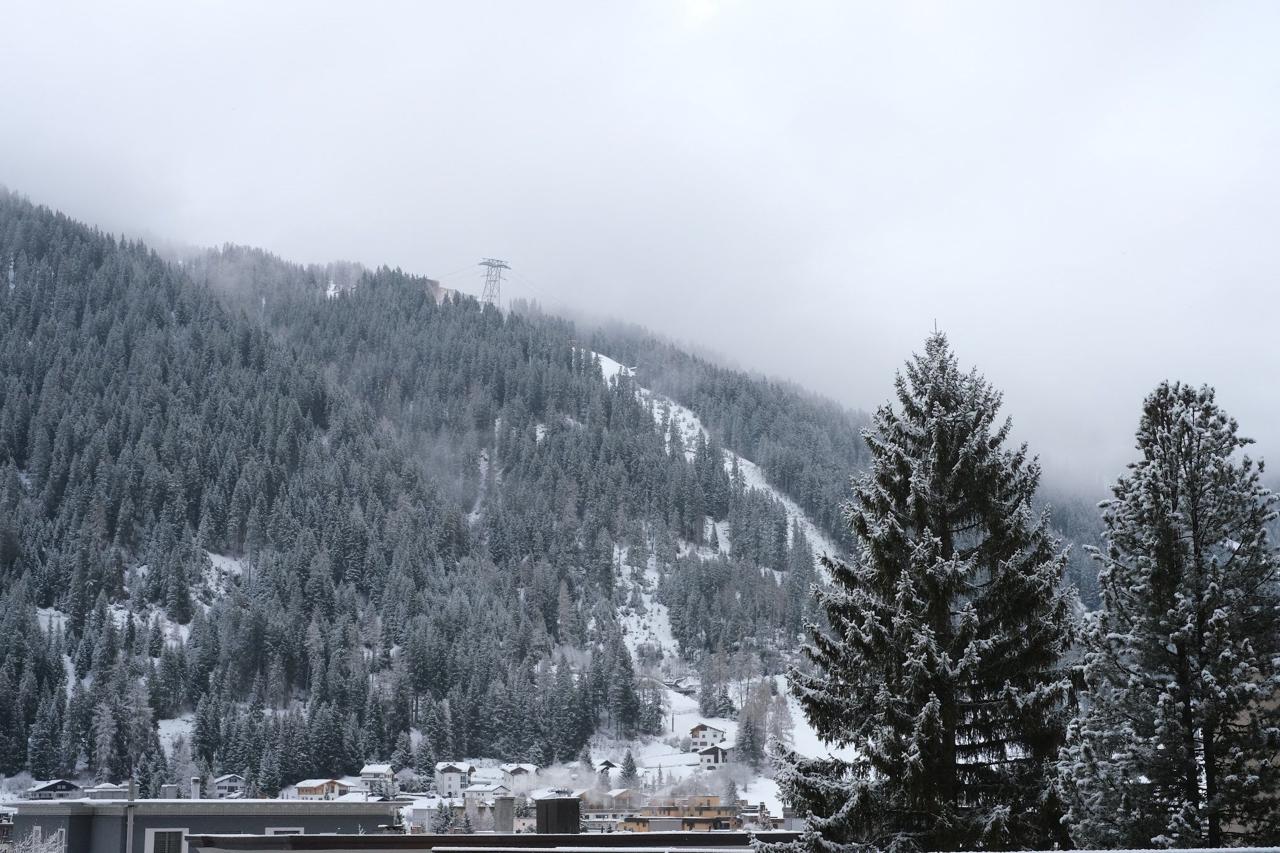 Davos village in winter with snow-covered forests and low clouds