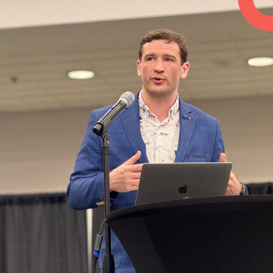 Frederik presenting at a DrupalCon Atlanta session podium in blue blazer and Aloha shirt