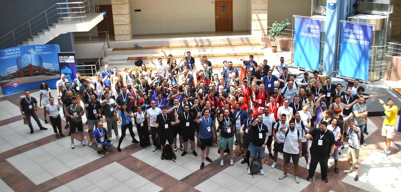 Full group photo from above at Burgas Free University - Drupal Developer Days 2024 banner visible, everyone waving and cheering
