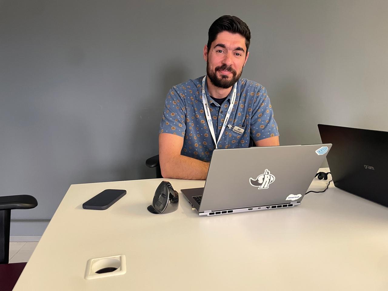 Bill Seremetis seated at a laptop during the Vibe Coding Challenge, focused on coding his Talos project