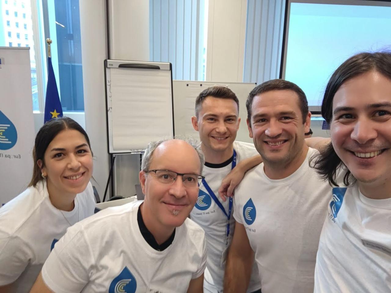 Squad 4 team selfie with Europa IT team t-shirts: five people smiling together at the European Commission