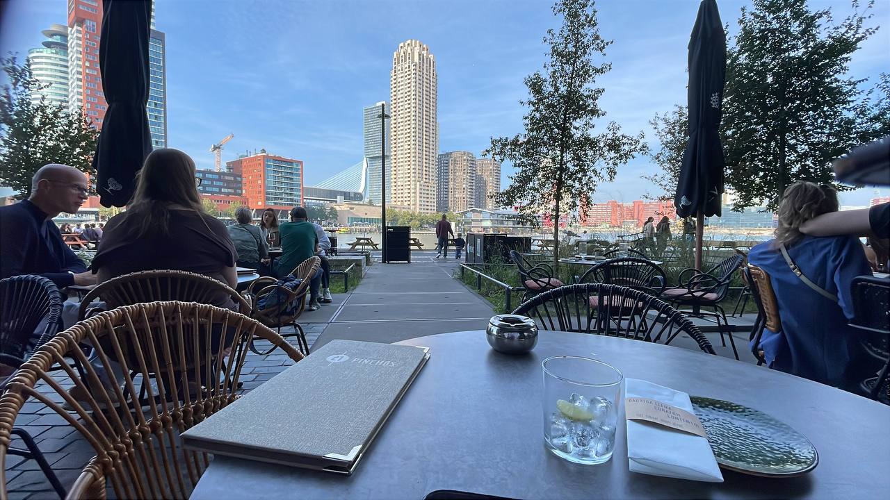 Terrace of 21 Pinchos restaurant in Rotterdam with the city skyline in the background, Pinchos menu on the table